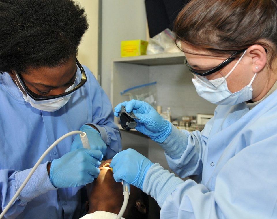 Two dental clinicians treating a patient
